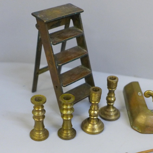 631A - A small collection of brass dolls house furniture; stepladder, four candlesticks, fireside fender, c... 