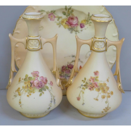 652 - A pair of Royal Worcester blush ivory twin handled vases and tea plate, decorated with sprays of flo... 