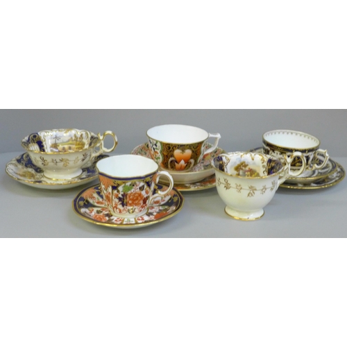 696 - A collection of Derby and Royal Crown Derby Queen's Imari cabinet cups and saucers; two with tea pla... 