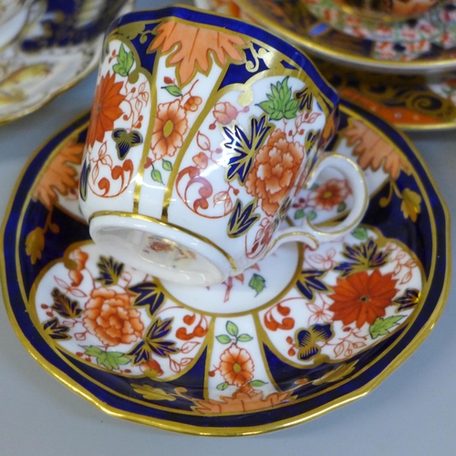 696 - A collection of Derby and Royal Crown Derby Queen's Imari cabinet cups and saucers; two with tea pla... 