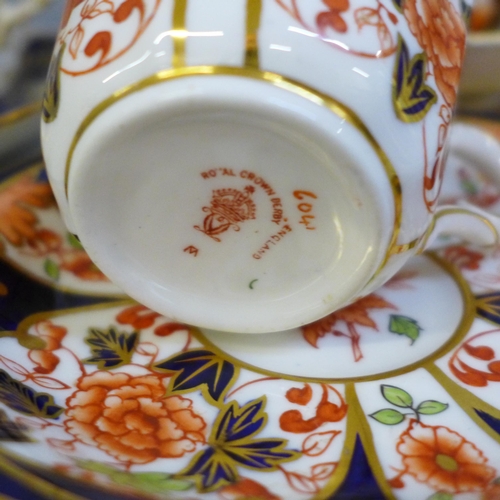 696 - A collection of Derby and Royal Crown Derby Queen's Imari cabinet cups and saucers; two with tea pla... 