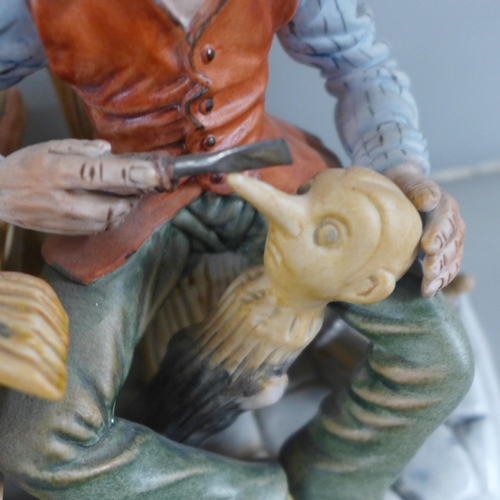 768 - A signed Capodimonte porcelain figure of Geppetto and Pinocchio