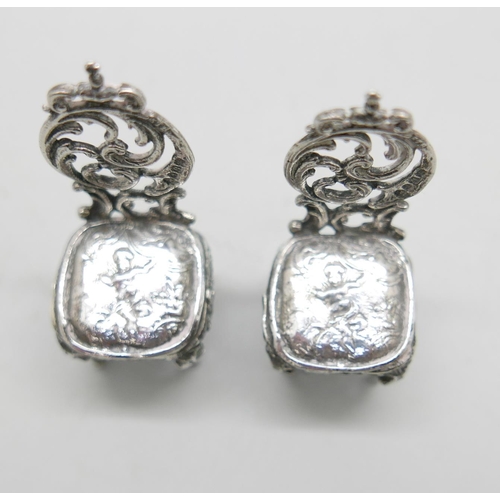 812 - A pair of silver miniature chairs with embossed cherub decoration, London 1897, 32g