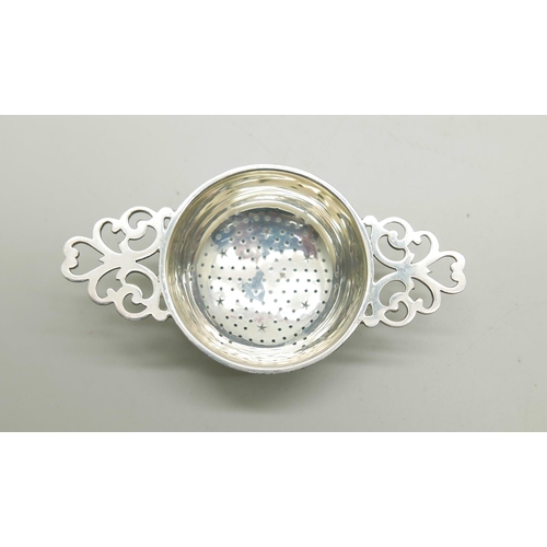 818 - A silver tea strainer, Birmingham 1933, 27g, on a silver plated stand