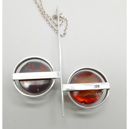 905 - A .830 silver Modernist style amber pendant, a silver and amber bracelet and another amber bracelet