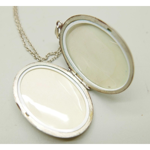 949 - Three silver lockets and chains, the largest by Fred Manshaw measuring 5cm including bale, 24g total