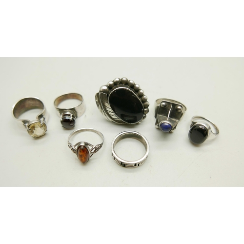 992 - Four silver rings including a Mexican example set with onyx, and three white metal rings, 44g