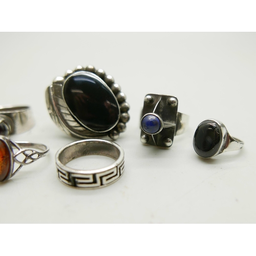 992 - Four silver rings including a Mexican example set with onyx, and three white metal rings, 44g