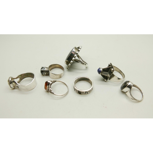 992 - Four silver rings including a Mexican example set with onyx, and three white metal rings, 44g