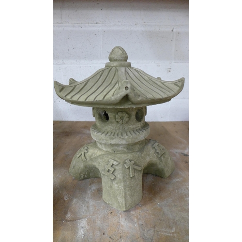 2236 - Two stone effect concrete Pagoda's and a stone effect concrete sitting Buddha figure