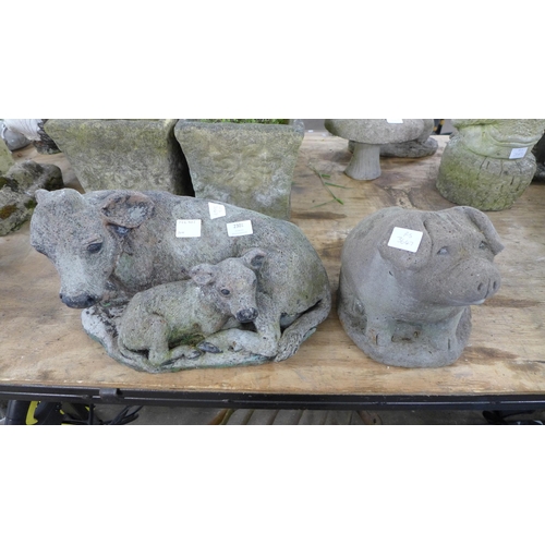 2301 - A concrete pig garden ornament and a concrete cow and calf ornament