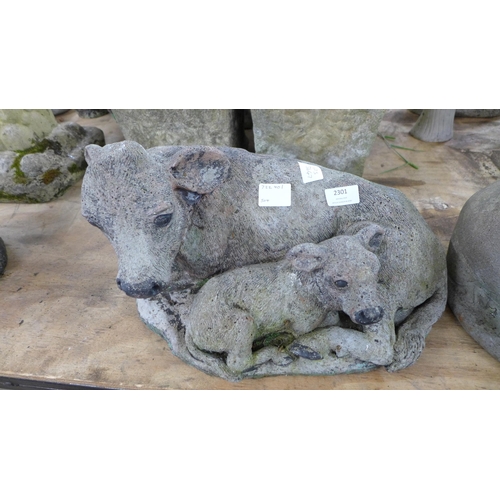 2301 - A concrete pig garden ornament and a concrete cow and calf ornament