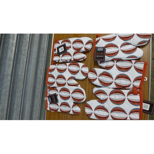 2345 - A large quantity of patterned kitchen/oven gloves and 30 x 46cm St. George Cross car flags