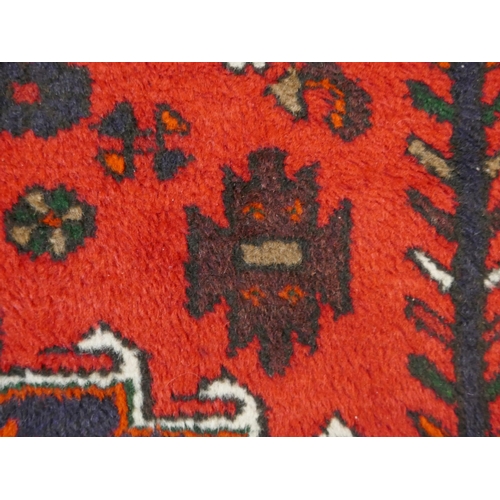 1501 - A Rich Red ground handwoven full wool pile Persian village rug (195x130cm)