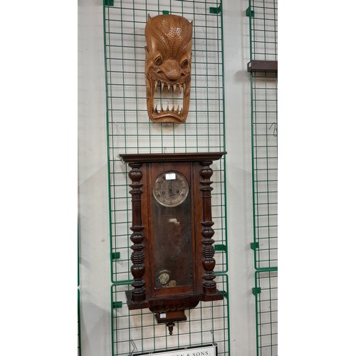 377 - A mahogany Vienna wall clock and a carved wood wall hanging face mask