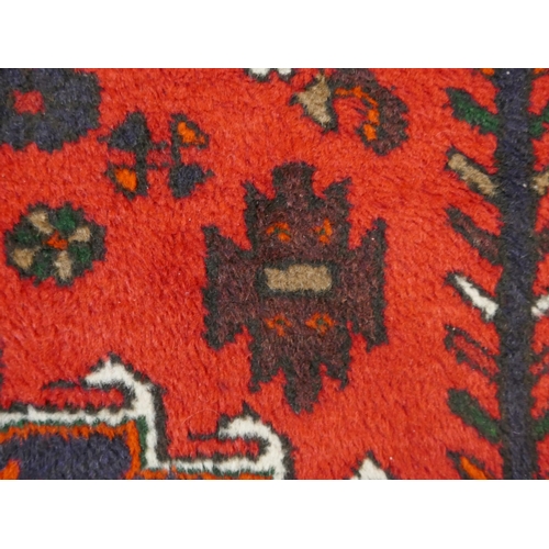 1340 - A Rich Red ground handwoven full wool pile Persian village rug (195x130cm)