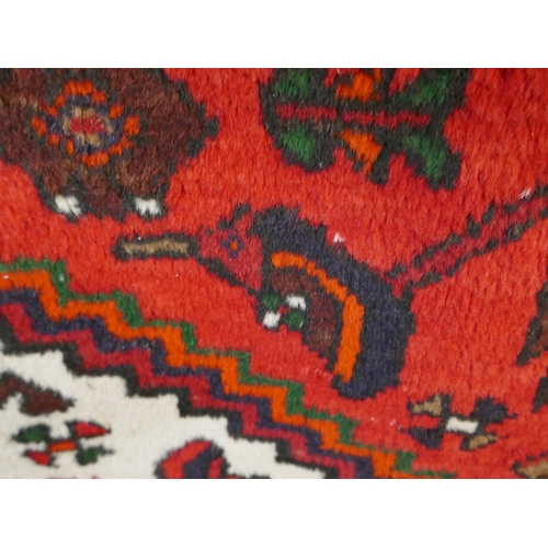 1340 - A Rich Red ground handwoven full wool pile Persian village rug (195x130cm)