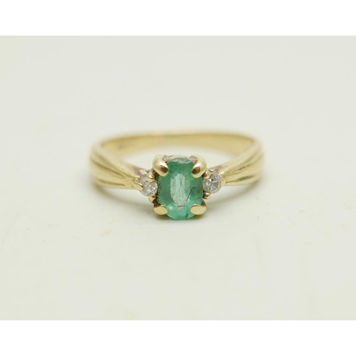 1023 - A 9ct gold ring set with an emerald and two small diamonds, 1.9g, J/K