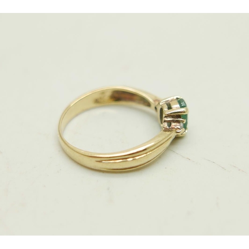 1023 - A 9ct gold ring set with an emerald and two small diamonds, 1.9g, J/K