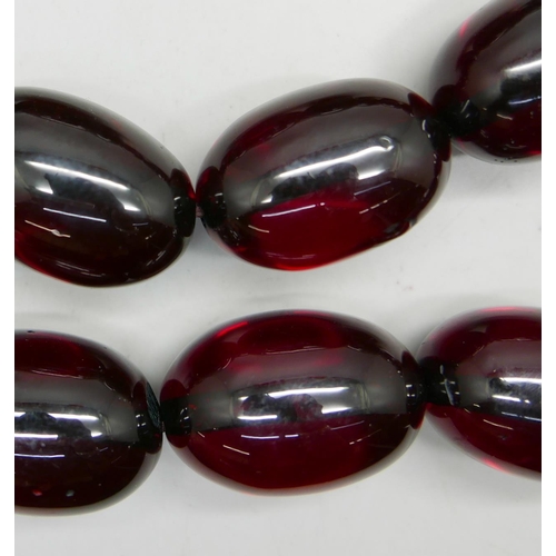 1033 - A large cherry coloured bead necklace, beads approximately 3cm x 4cm, 140cm