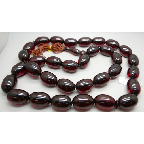 1033 - A large cherry coloured bead necklace, beads approximately 3cm x 4cm, 140cm