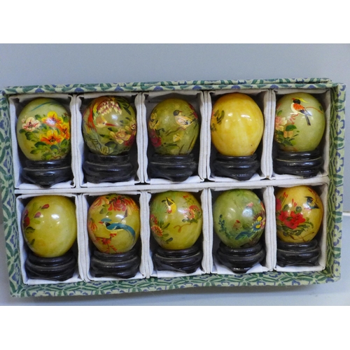 636 - Ten hand carved and hand painted jade eggs with wooden stands, in presentation box