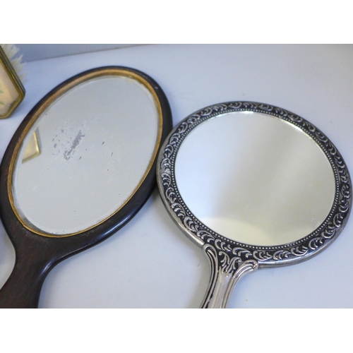 650 - A vintage dressing table set, an ebony and silver dressing mirror, a silver toned mirror and a tapes... 