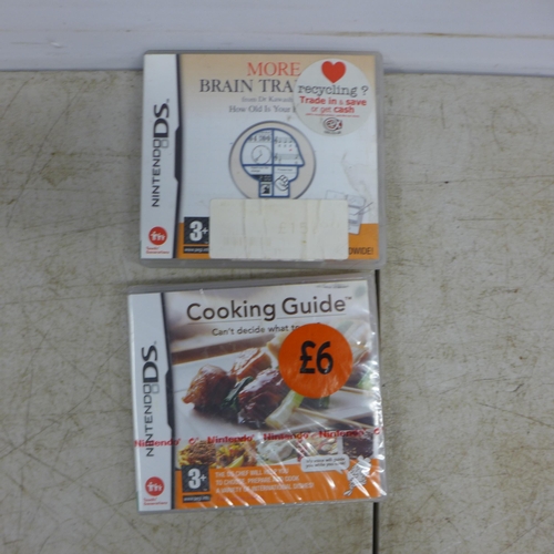 2083 - A boxed matte black Nintendo DSi with charger and two games including Cooking Guide and More Brain T... 