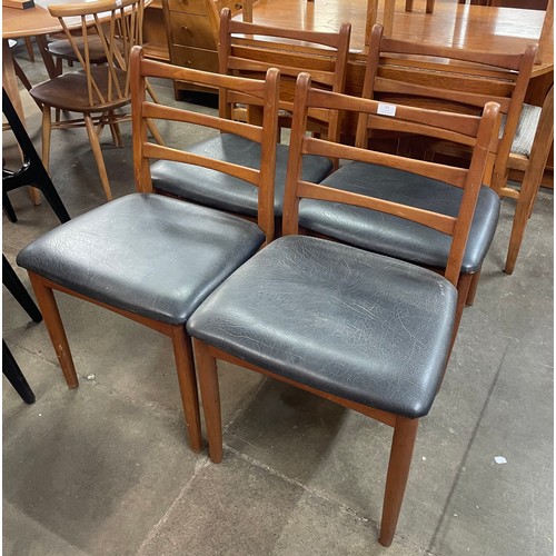 82 - A set of four teak and black vinyl dining chairs