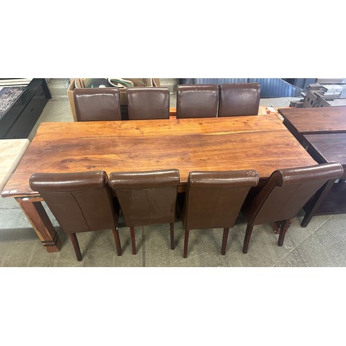 1540 - A large Indian hardwood dining table and eight brown leather and black piping dining chairs