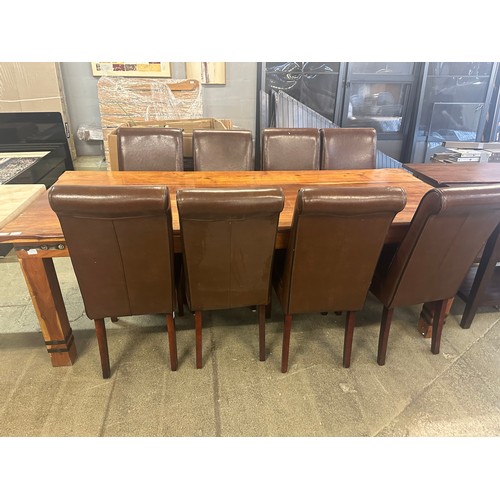 1540 - A large Indian hardwood dining table and eight brown leather and black piping dining chairs