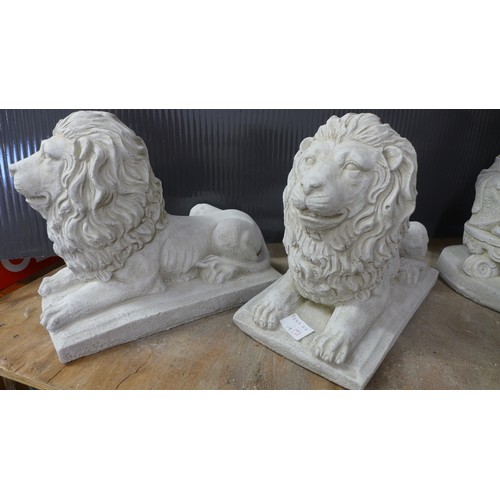 2333 - A pair of small stone effect concrete ornaments of lions laying down