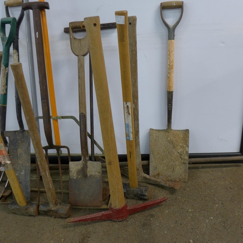 2294 - A quantity of garden tools including hammers, a pick axe, shovels, a spirit level, a pitch fork, etc... 