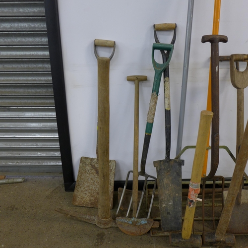 2294 - A quantity of garden tools including hammers, a pick axe, shovels, a spirit level, a pitch fork, etc... 