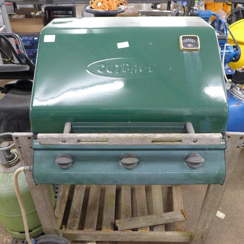 2367 - An Outback three burner gas barbecue with a part full calor gas bottle