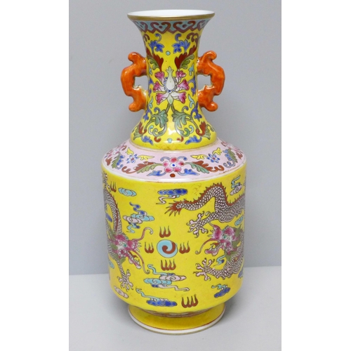 603 - A Chinese porcelain vase on yellow ground with dragon detail, six character mark to base, 23cm