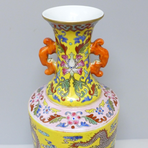 603 - A Chinese porcelain vase on yellow ground with dragon detail, six character mark to base, 23cm