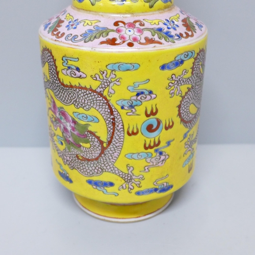 603 - A Chinese porcelain vase on yellow ground with dragon detail, six character mark to base, 23cm