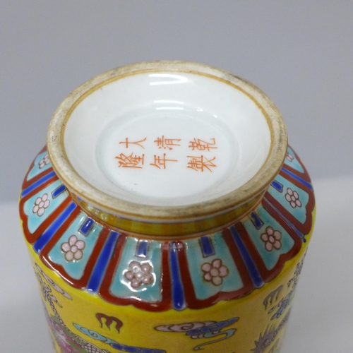 603 - A Chinese porcelain vase on yellow ground with dragon detail, six character mark to base, 23cm