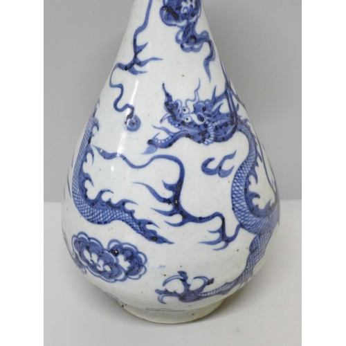 605 - A Chinese porcelain blue and white vase decorated with a dragon and clouds, 26.5cm