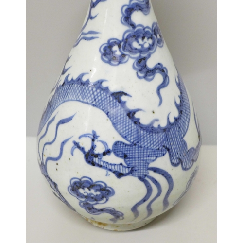 605 - A Chinese porcelain blue and white vase decorated with a dragon and clouds, 26.5cm