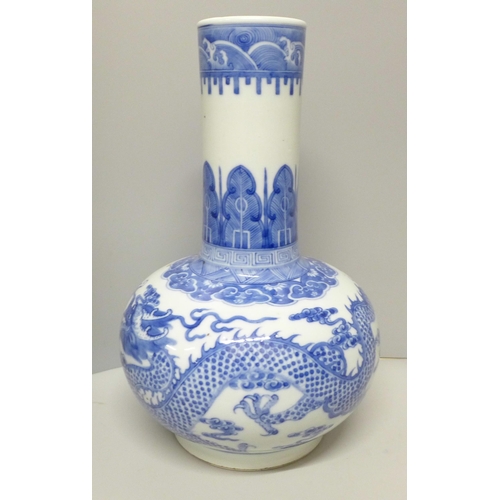 609 - A Chinese porcelain blue and white bottle vase, Kangxi mark, decorated with a dragon and clouds, 34.... 