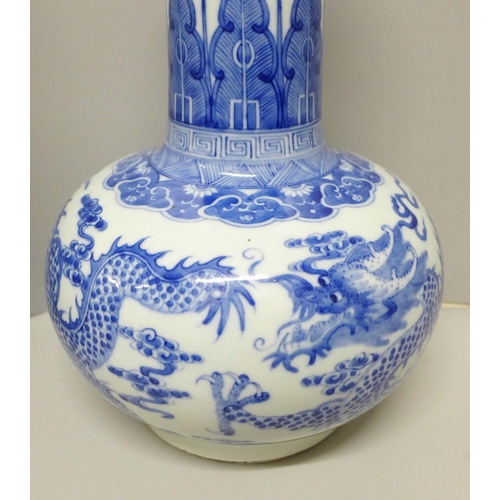 609 - A Chinese porcelain blue and white bottle vase, Kangxi mark, decorated with a dragon and clouds, 34.... 