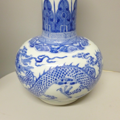 609 - A Chinese porcelain blue and white bottle vase, Kangxi mark, decorated with a dragon and clouds, 34.... 