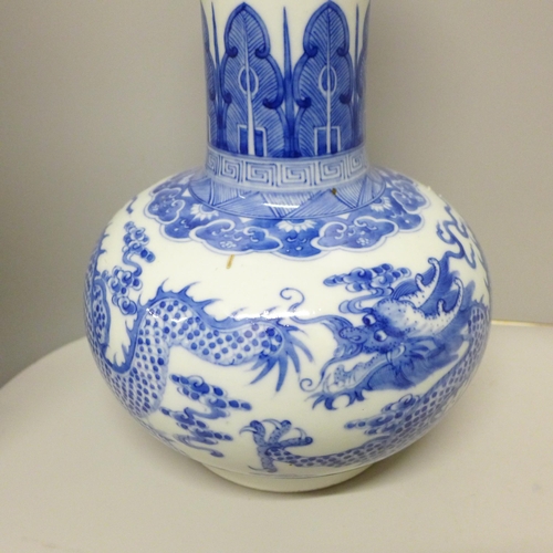 609 - A Chinese porcelain blue and white bottle vase, Kangxi mark, decorated with a dragon and clouds, 34.... 