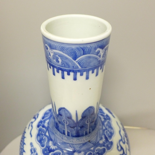 609 - A Chinese porcelain blue and white bottle vase, Kangxi mark, decorated with a dragon and clouds, 34.... 