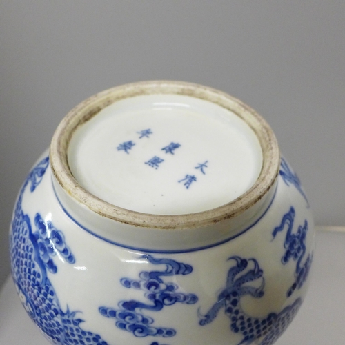 609 - A Chinese porcelain blue and white bottle vase, Kangxi mark, decorated with a dragon and clouds, 34.... 