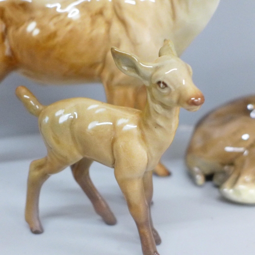 642 - A Beswick stag, doe and fawn, one antler on stag chipped