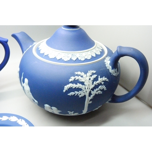 662 - A Wedgwood dark blue Jasperware teapot, mug, pitcher,  and cylindrical vase and pin tray