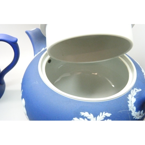 662 - A Wedgwood dark blue Jasperware teapot, mug, pitcher,  and cylindrical vase and pin tray